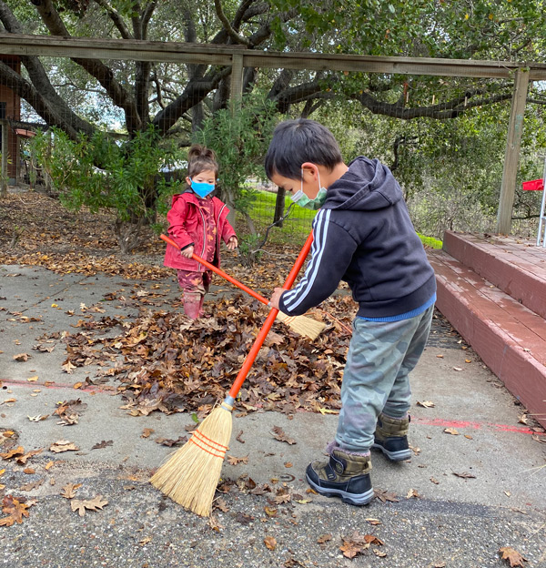 Students sweeping leaves