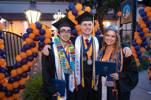 Three smiling graduates
