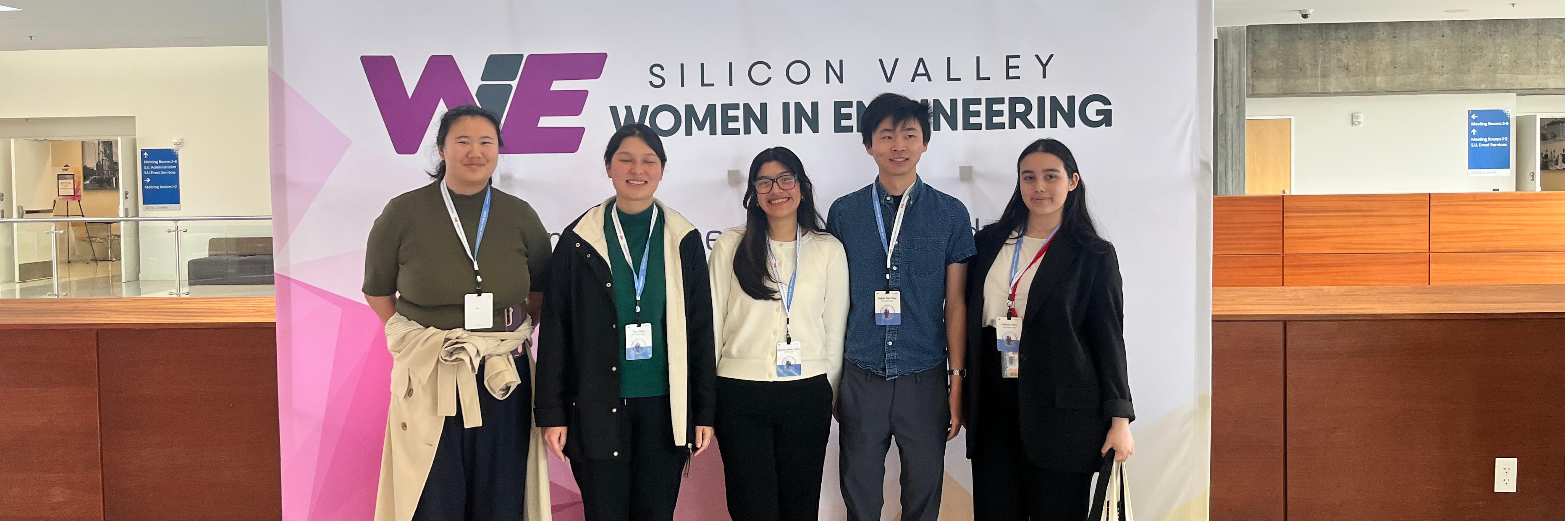 MESA students in front of Women in Engineering Conference photo backdrop
