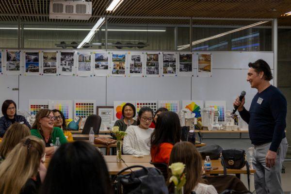 man with microphone talking to members sitting at tables