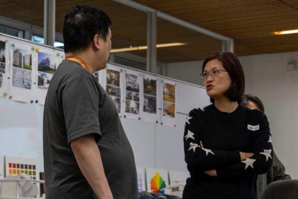 two interior design students wearing black talking to each other