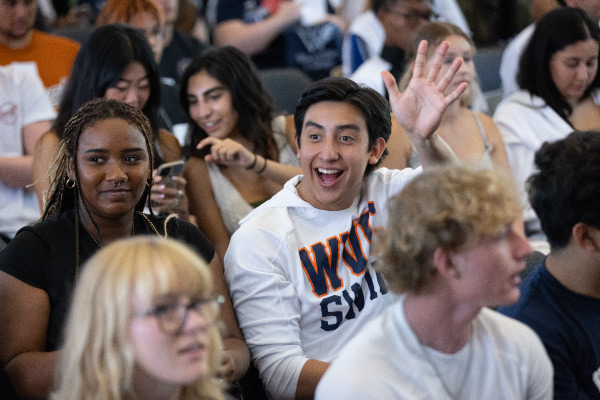 Student waving in audience