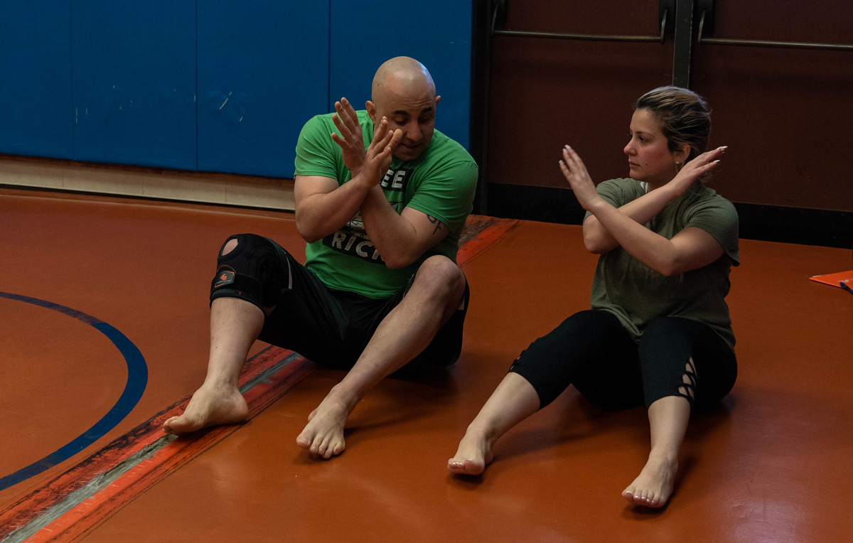 Instructor guiding student during combative class