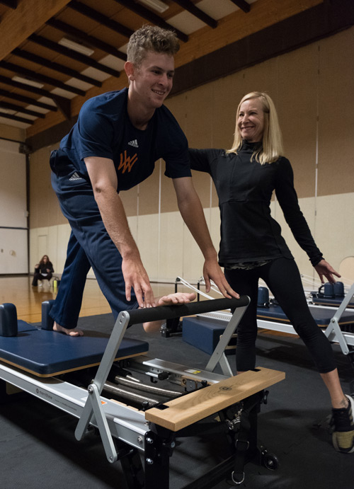 Instructor with student on pilates machine