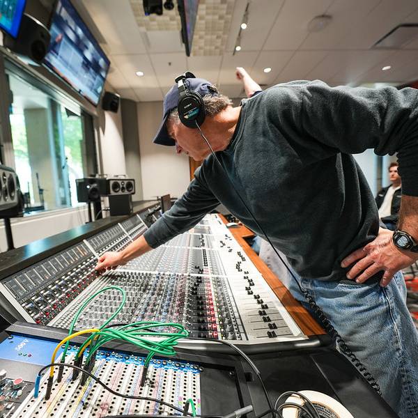 man wearing audio monitors using the recording console