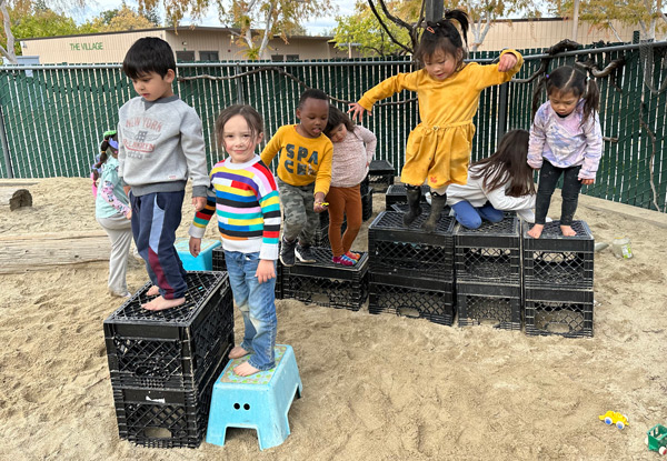 Children jumping off crates