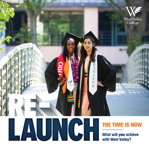 Two female students in graduation garb on bridge