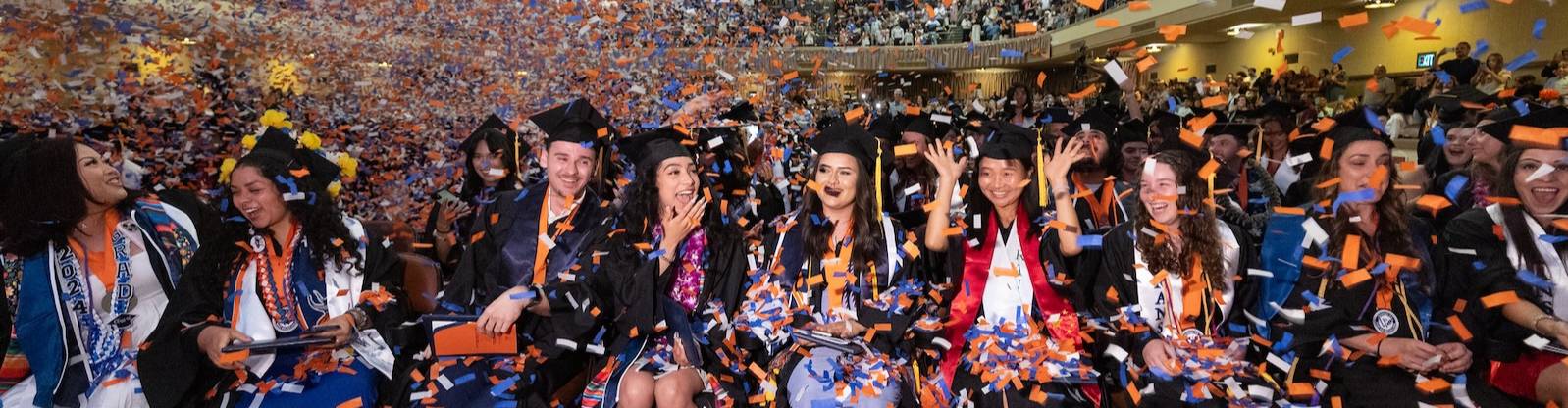 Smiling graduates with confetti