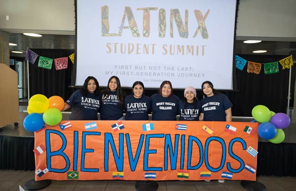 Latinx students holding orange Bienvenidos banner