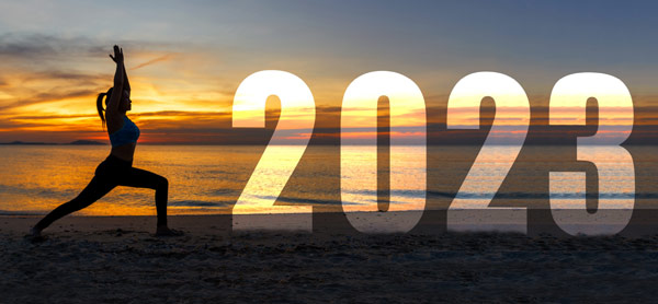 Silhouette posed on beach with large 2023 text