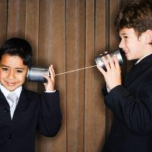 Two suited boys speaking on stringed cans