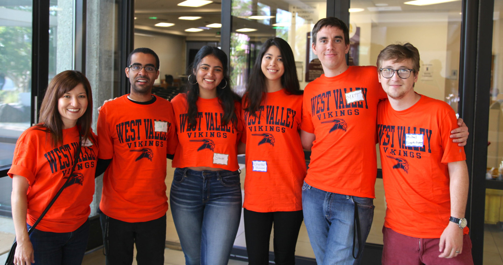 Diverse students wearing orange students in Campus Center Diverse students wearing orange students in Campus Center