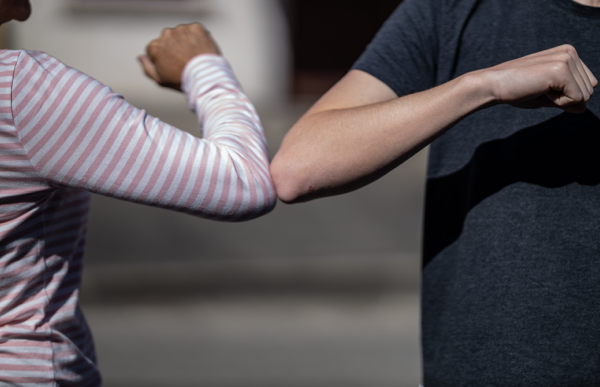 two people elbow bumping as a greeting