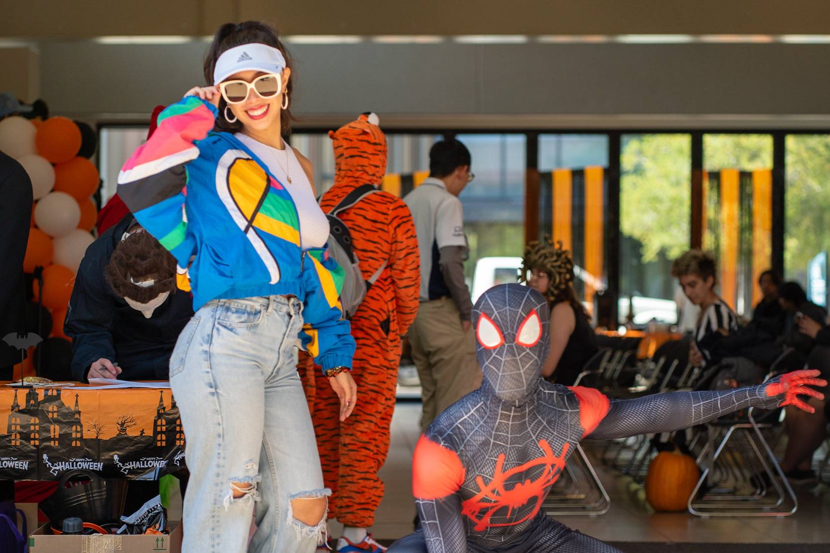 two students dressed for halloween - one in 60s theme, one in a black spiderman costume