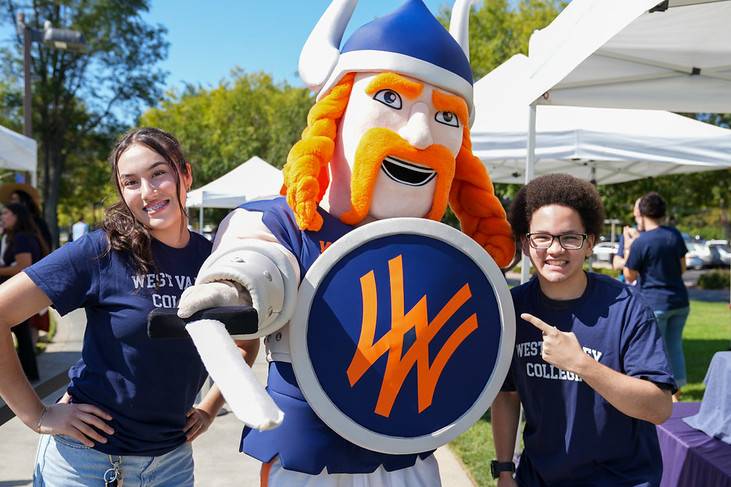 two students posing with vik the viking