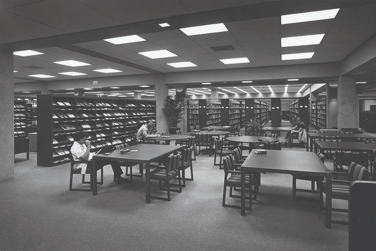 black and white photo of the old library location with bookcases and desk study area
