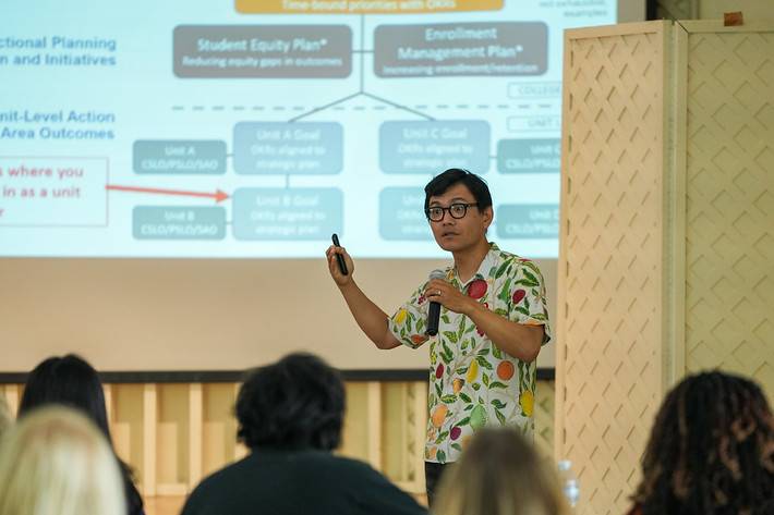 dean horibe wearing a fruit pattern shirt presenting the OKR framework at the summer leadership retreat 2025