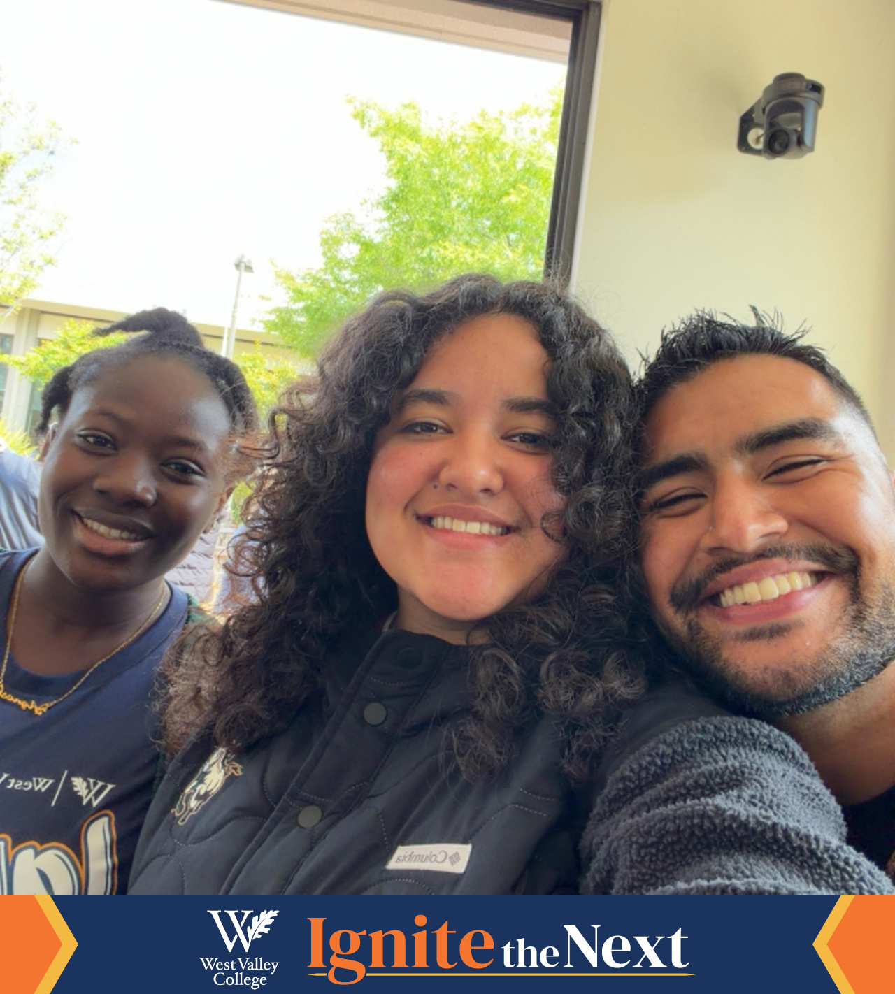three students smiling to camera