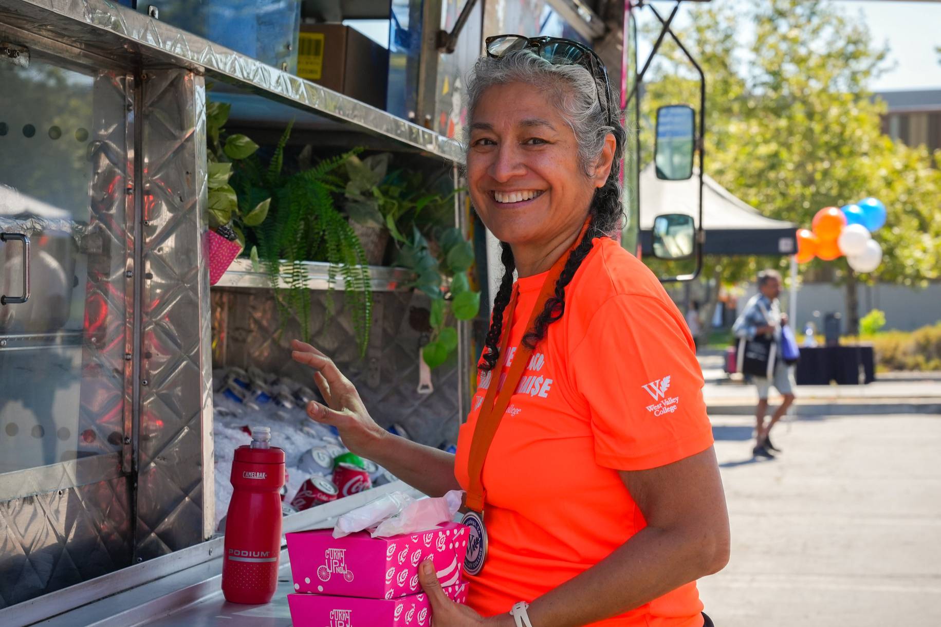 a tour de saratoga participant wearing a bright orange shirt ordering food at a food truck