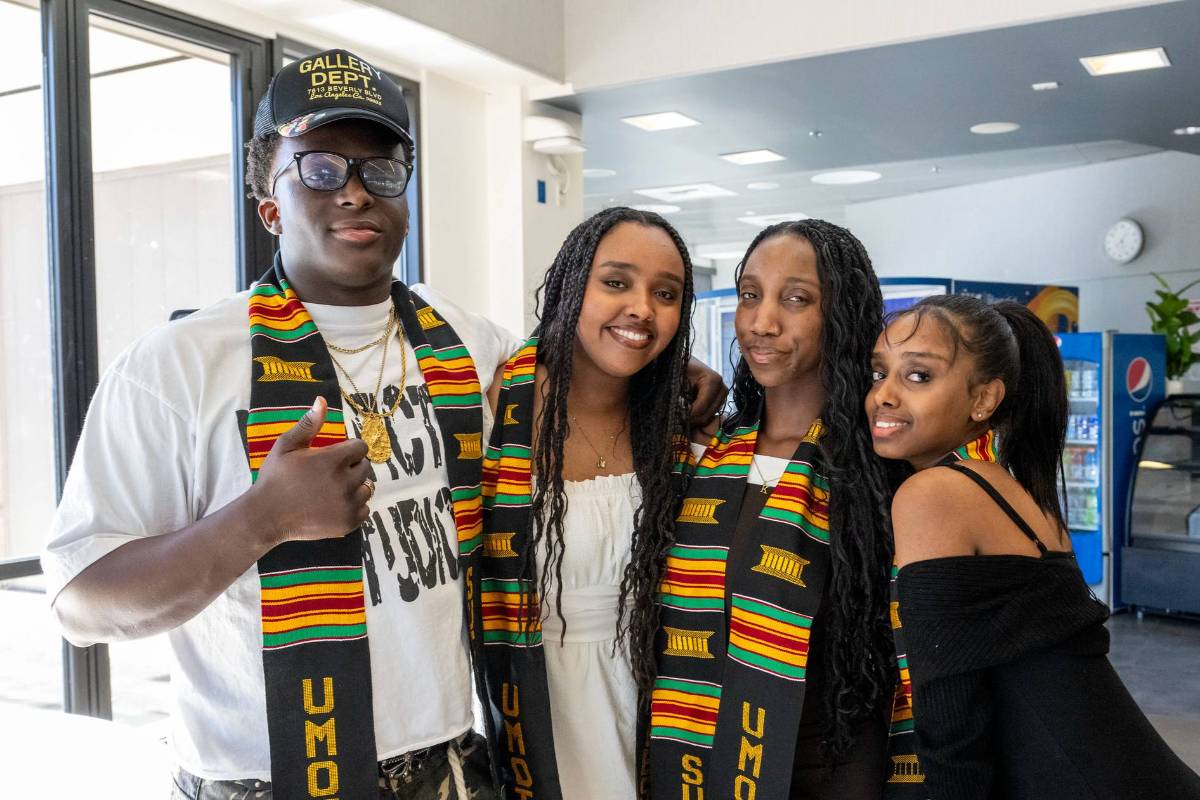 group of four umoja students wearing umoja stoles