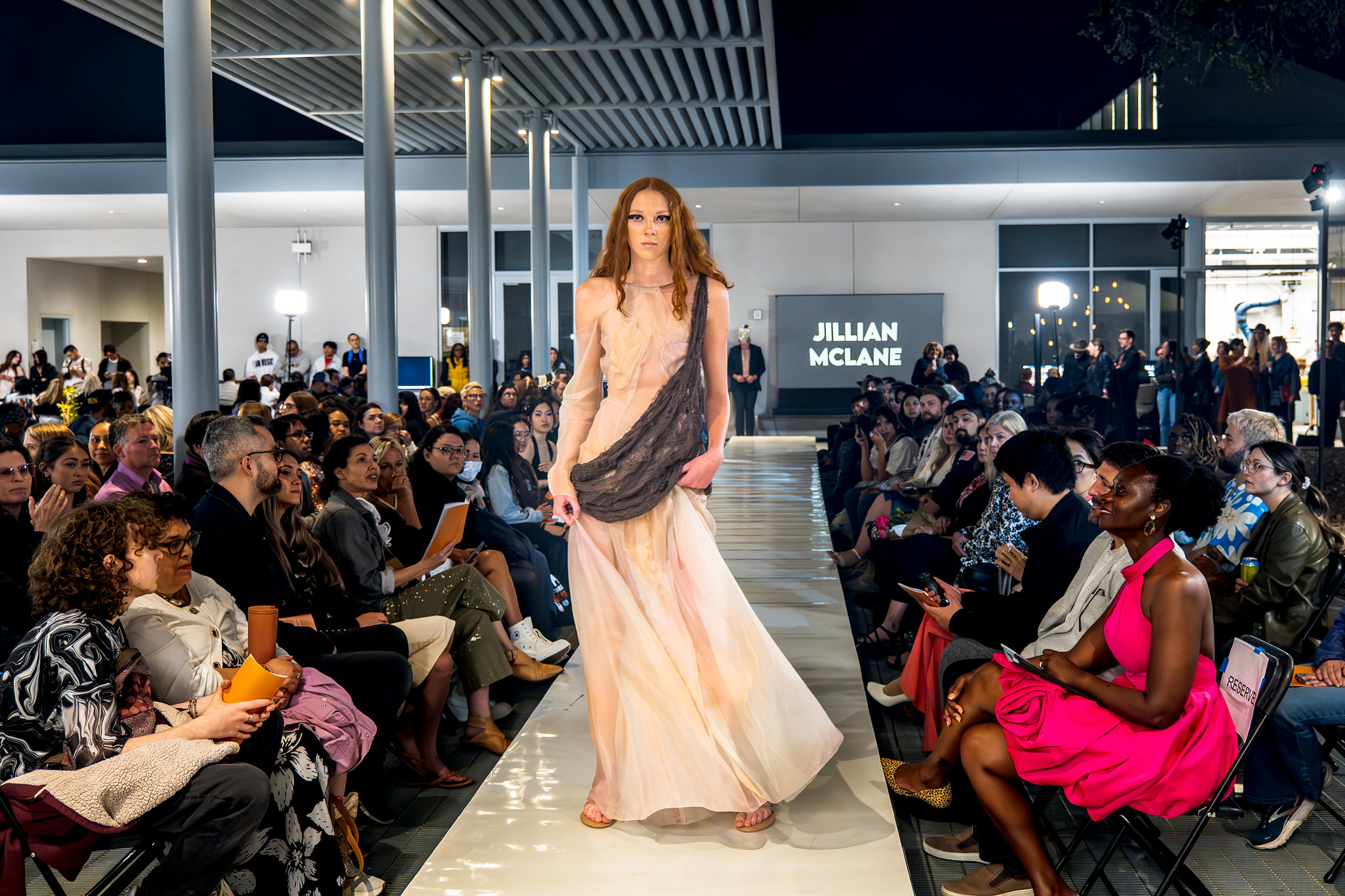 steamd fashion show - model wearing white sheer dress with grey sling accent