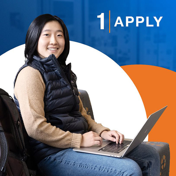 Smiling female student in wheelchair with laptop