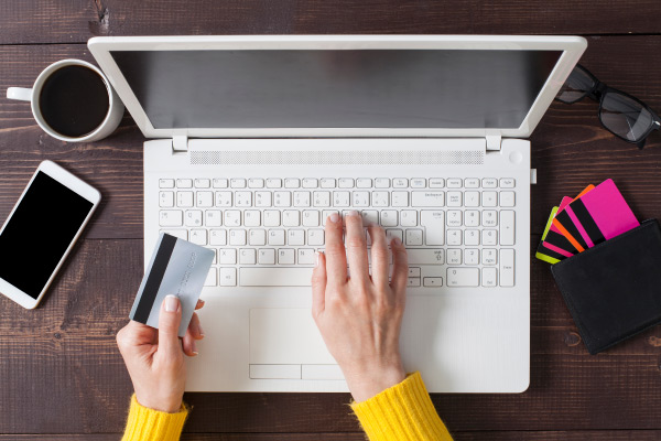 Hands with credit card on laptop