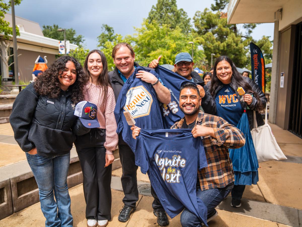 students and staff at the brand refresh party holding ignite the next tshirts