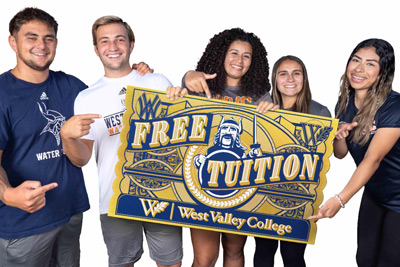 Students holding free tuition sign Students holding free tuition sign