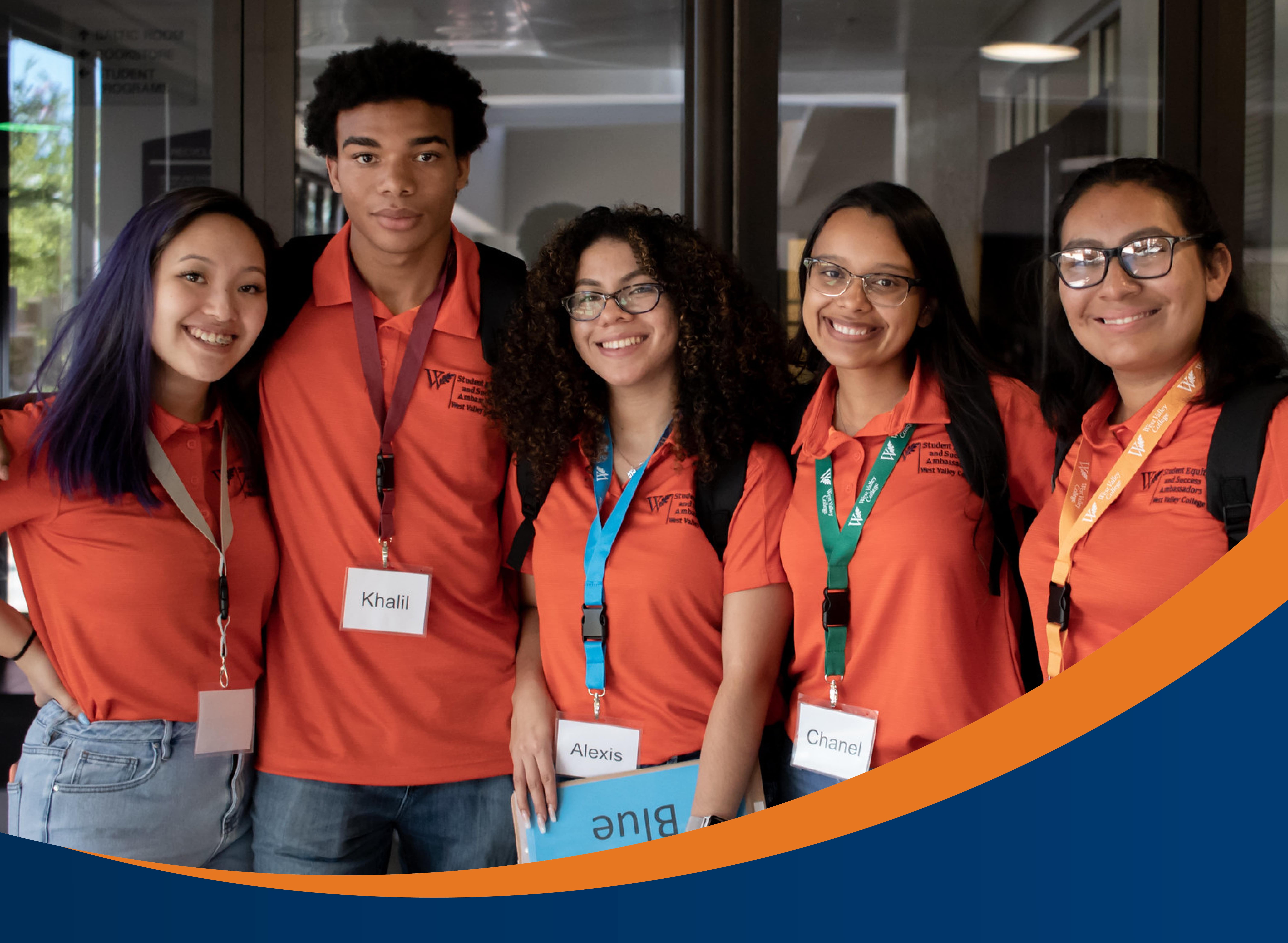 group of five students wearing orange wvc branded shirts