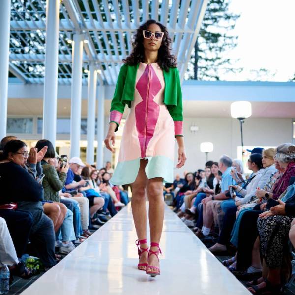 a fashion model walking down a catwalk weating student designed clothing