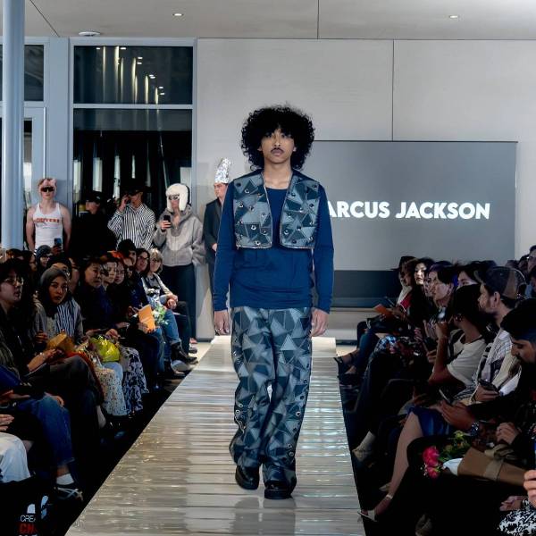 a fashion model walking down a catwalk weating student designed clothing