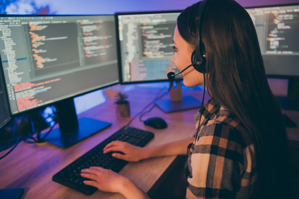 Human in front of monitors with headphones