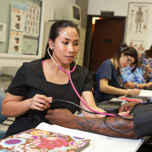 Students practice with taking blood pressure in class