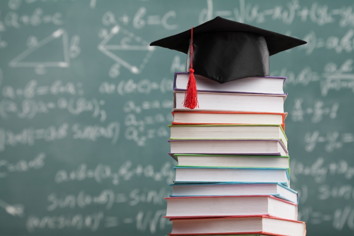 grad cap on top of a stack of books