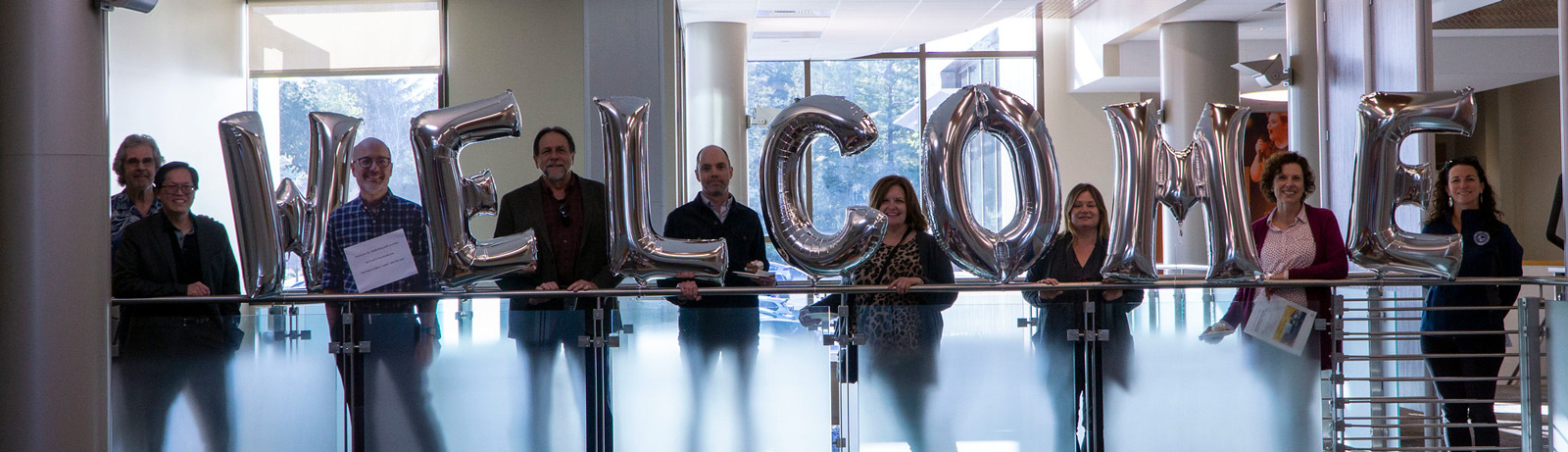 Employees gathered with welcome balloons during opening event