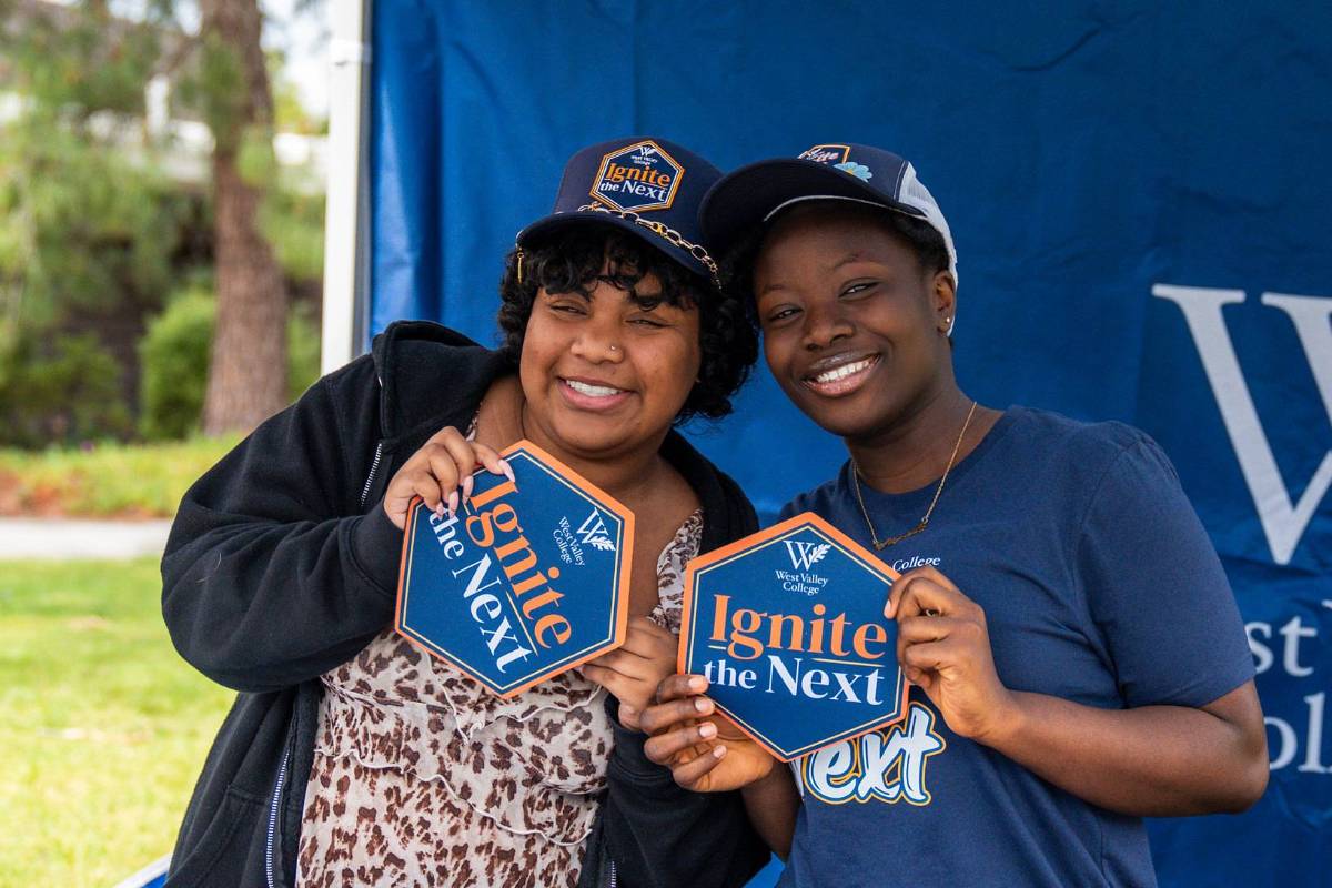two female students holding ignite the next merch two female students holding ignite the next merch